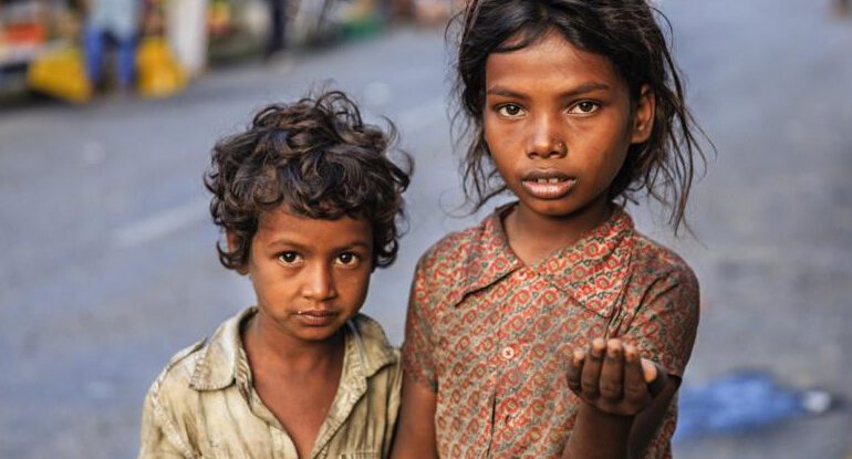 Two children standing next to each other on a street.