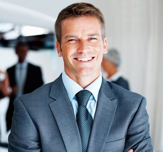 A man in a suit and tie smiling for the camera.