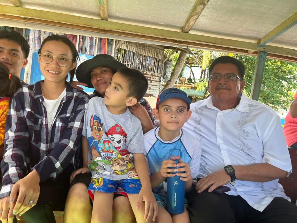 A family sitting on the back of a bus.